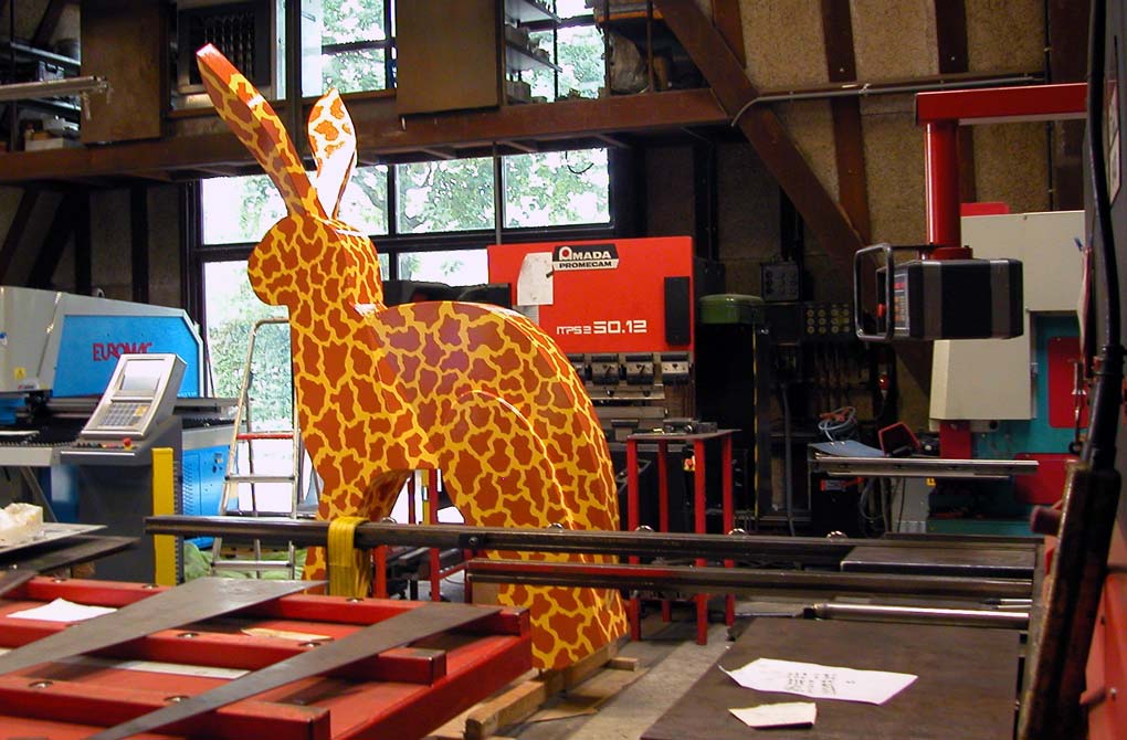 Tussen apparaten staat het geschilderde beeld Dit is een giraf, ceci est une girafe, this is a giraf, &copy; Andr&eacute; Boone