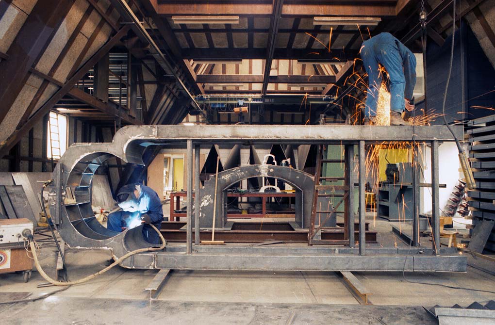 het stalen portaal horizontaal in het atelier. Er wordt tegelijkertijd aangelast en geslepen &copy; Andr&eacute; Boone