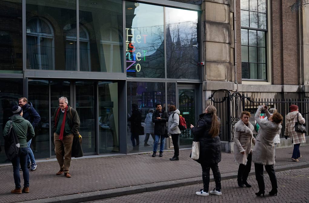 Na een periode van restauratie staat het beeld weer voor de ingang van het gebouw van de parlementaire enqu�te commissie 2023. Voorbijgangers fotograferen het werk.