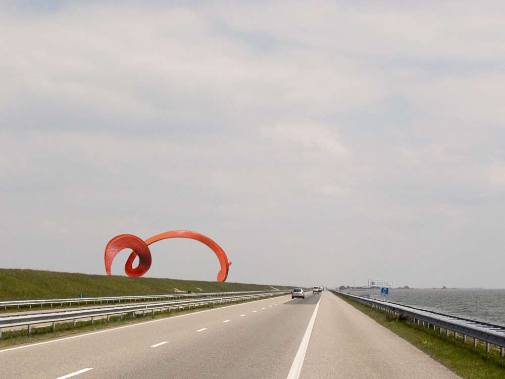 het ontwerp een oorijzer van een monumentale maatvoering. Het is een langgerekte vorm uitgevoerd in cortenstaal van ongeveer 30 meter lang, 8 meter hoog en 10 meter breed, Op het eerste gezicht ziet de vorm er uit als een golf die tegen de dijk slaat. Zij vertoont telkens een andere aanblik in het passeren. &copy; Andr&eacute; Boone