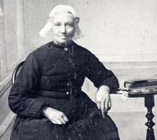een vrouw met oorijzer en vrij lange floddermuts, omstreeks 1900