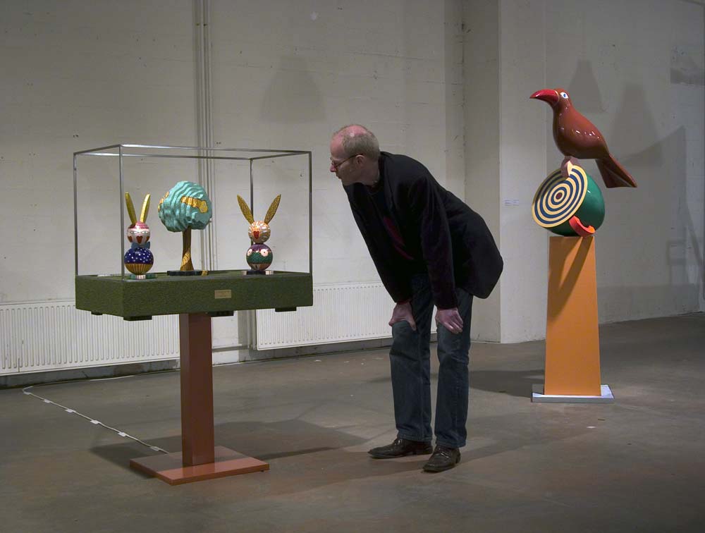 in een kader waar muziek uit komt, het walsje An der sch&ouml;nen blauen Donau, staan twee hazen, manlijk en vrouwelijk met in het midden een gekleurde boom. Het beeld wordt door een bezoeker tijdens de tentoonstelling bekeken, &copy; Andr&eacute; Boone